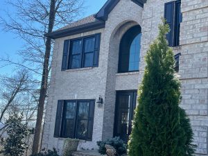 Black framed windows on a white brick home.