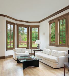 A living room with wood-framed windows installed.